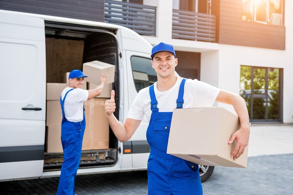Two Removal Company Workers Unloading Boxes