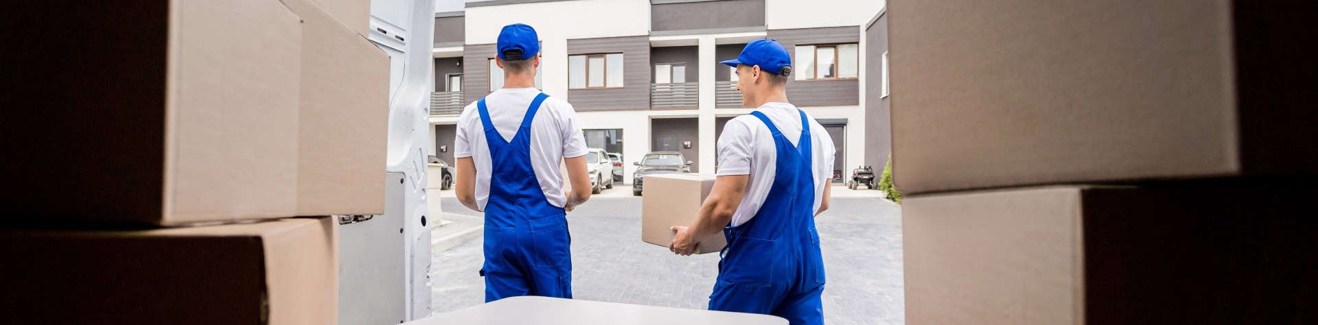 two-removal-company-workers-unloading-boxes-from-minibus